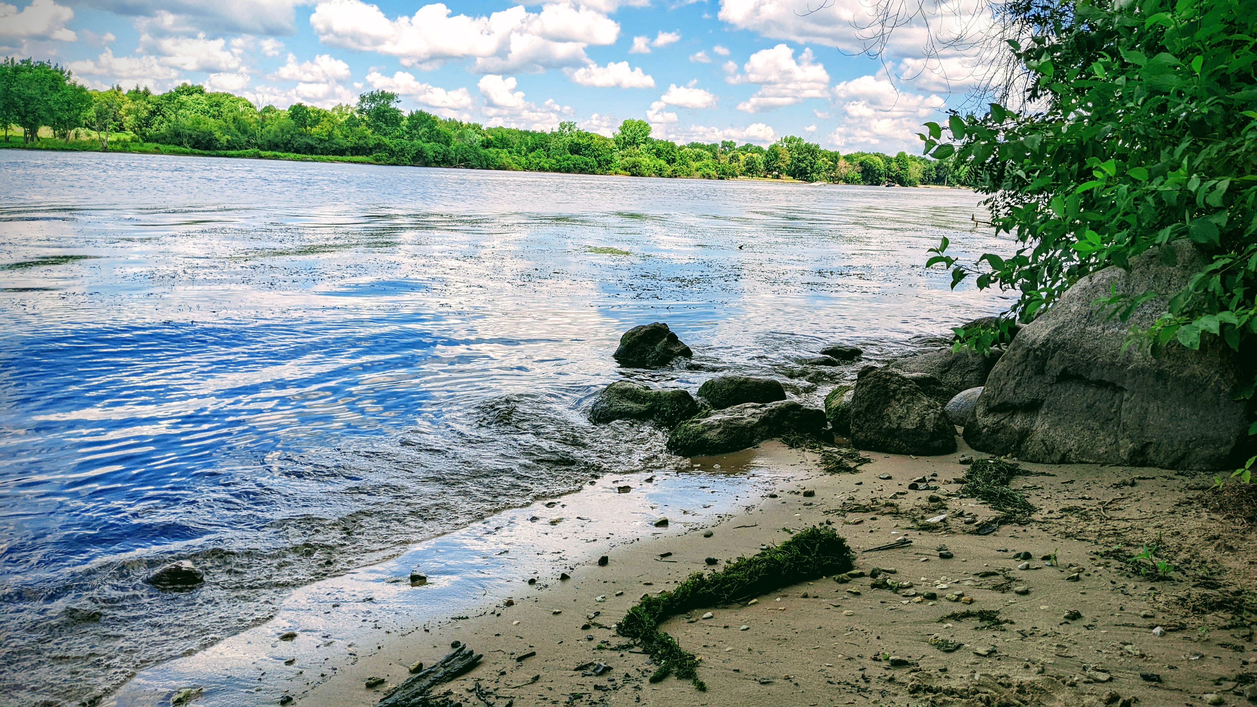 Waves reach the shore along the riverside