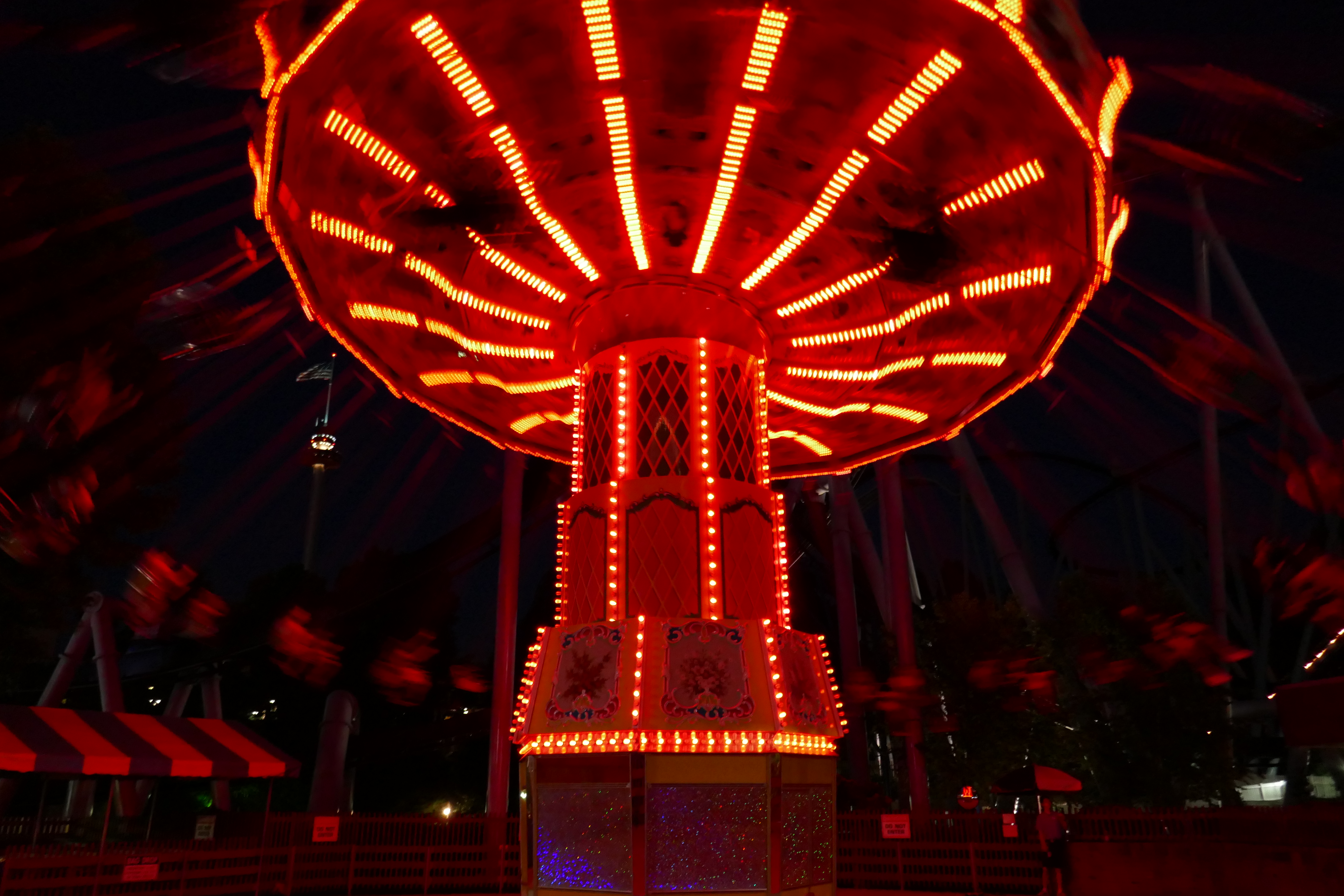 Themepark swing ride at night illuminated red
