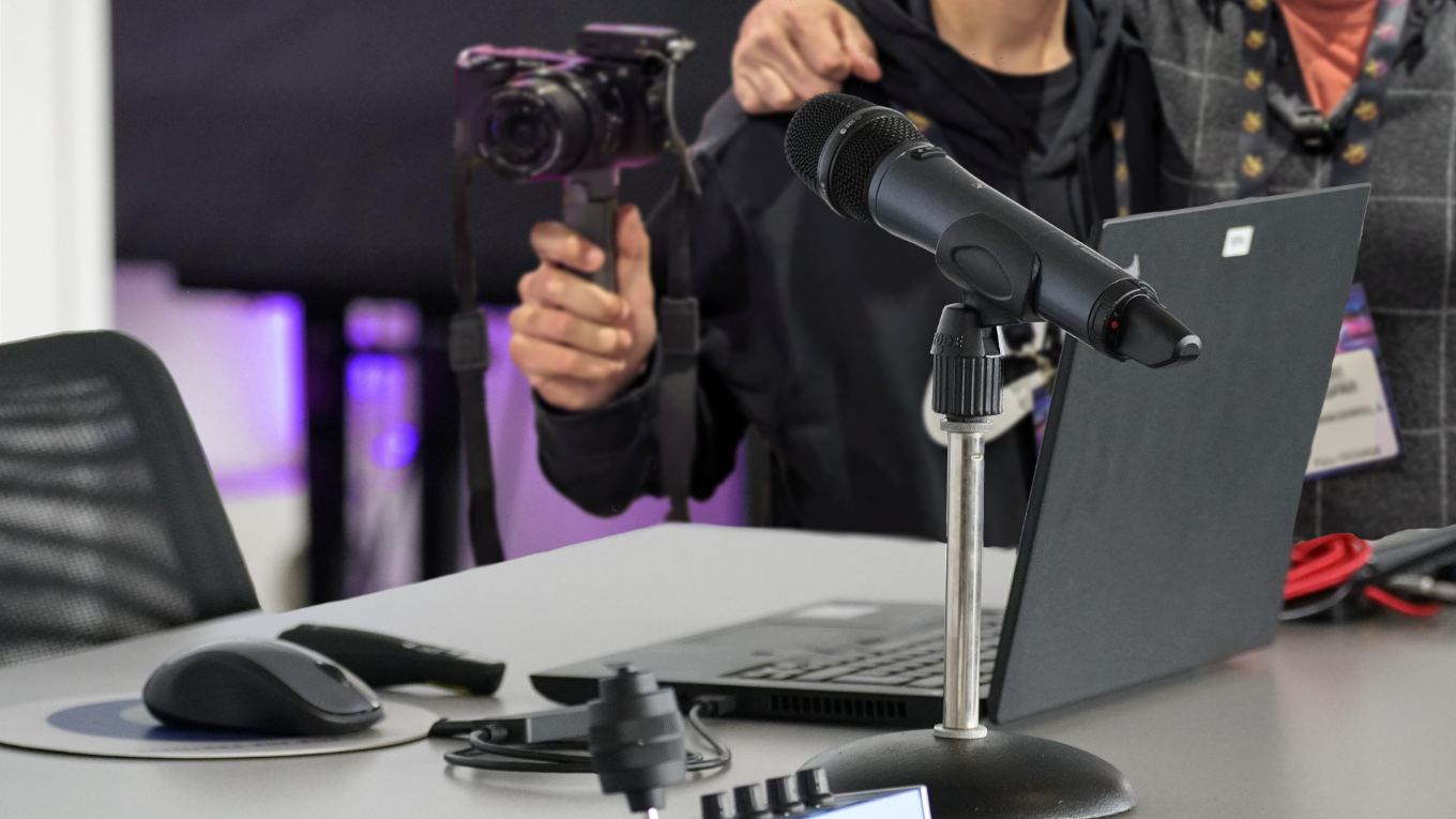 A camera man and another guy getting ready to record at a microphone
